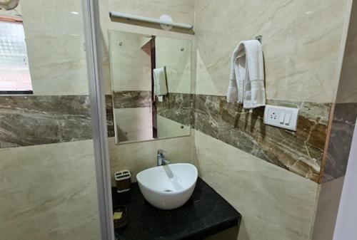a bathroom with a white sink and a mirror at zoz Baga in Baga