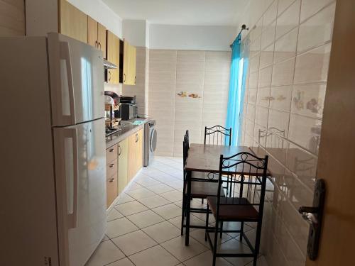 a kitchen with a table and chairs and a refrigerator at Appartement Marhaba in Agadir