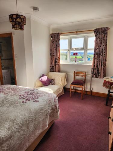 een slaapkamer met een bed, een stoel en een raam bij Swallows Rest in Weymouth