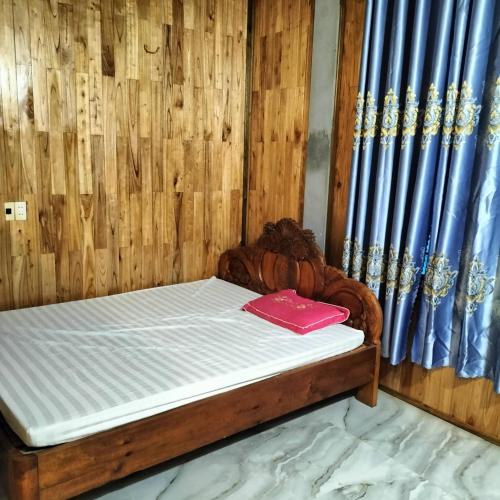 a bed with a red book on top of it at Homestay and Hots Spring Huy Hường in Yên Bái