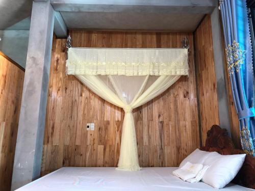 a bedroom with a bed with a curtain at Homestay and Hots Spring Huy Hường in Yên Bái