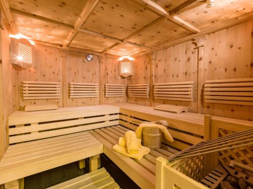 a sauna with wooden walls and benches and a yellow towel at S'Dörfl Chalets in Mayrhofen