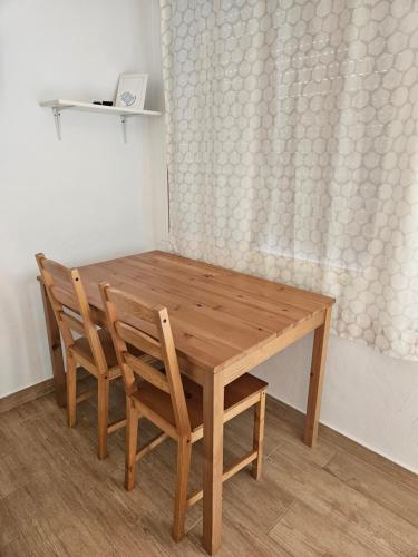 una mesa de madera y sillas en una habitación en Casita La Raiz en Barbate