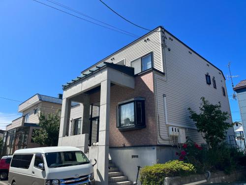 a white van parked in front of a house at SharedHouse新琴似,駐車無料,予約要,最大6名,車で最寄り駅お迎え可能,麻生駅バス直通 in Sapporo