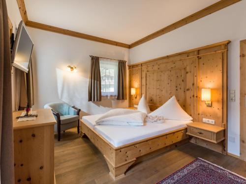 a bedroom with a bed and a desk and a chair at S'Dörfl Chalets in Mayrhofen