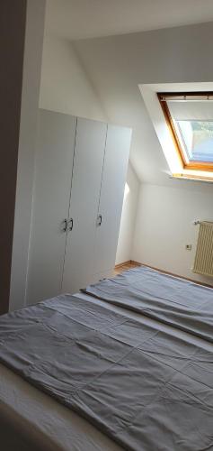 ein weißes Zimmer mit einem Bett und einem Fenster in der Unterkunft FW 3 Zimmer 1OG 80qm 