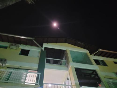 a view of a house at night with a moon at Solar do Forte Flats in Ubatuba