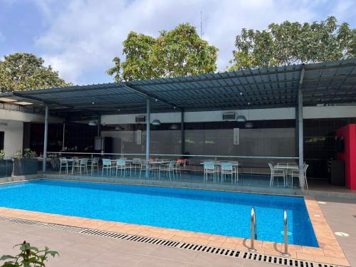 a pool with a pavilion with tables and chairs at Residence ACHENBACH in Abidjan