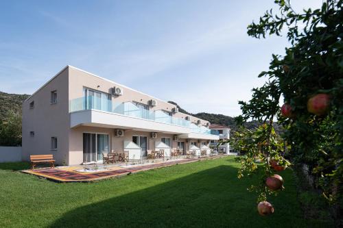 a large white building with a large yard at Diva Lodge in Sikia
