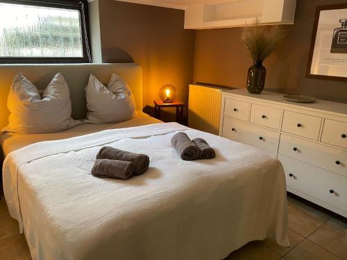 Un dormitorio con una cama blanca con toallas. en In Abrahams Schoß, en Blankenfelde