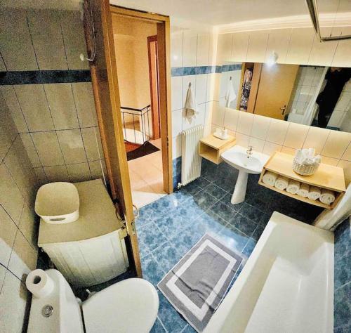 een badkamer met een wit toilet en een wastafel bij 3 Bedrooms Maisonette in Patra
