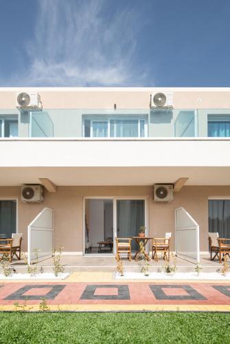 a building with tables and chairs in front of it at Diva Lodge in Sikia