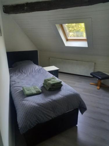 ein Schlafzimmer mit einem Bett mit zwei grünen Handtüchern darauf in der Unterkunft joseph in Monschau