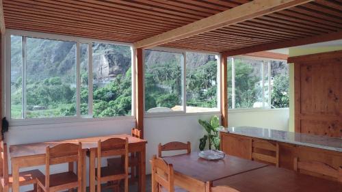 um quarto com uma mesa, cadeiras e janelas em Oasis Paul Residencial em Paul