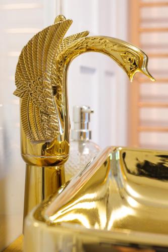a bathroom sink with a gold faucet on it at Executive Suite with Private HotTub, Full SkyTV in 600 Year Old Manor House in Saffron Walden