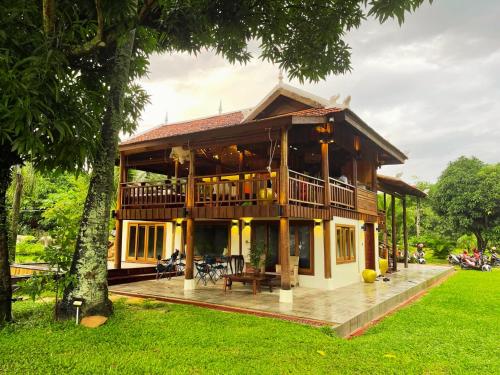 a large house with a balcony and a yard at Devi Kampot Resort at Phum Kampot in Kampot
