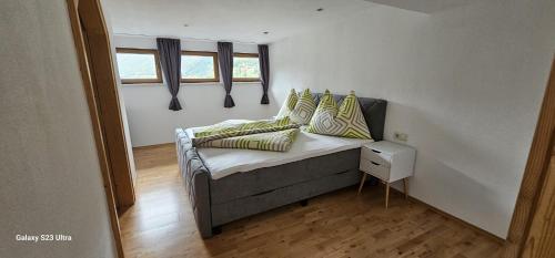 a room with a couch with pillows and a window at Ferienwohnung Schranz in Flirsch