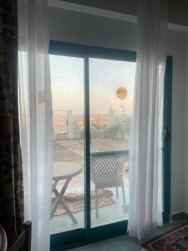 uma vista para um pátio a partir de uma janela com uma mesa em A cozy room in 2 bedrooms apartment with a back yard em Sharm el Sheikh