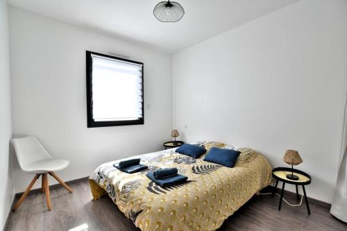 - une chambre avec un lit doté d'oreillers bleus et d'une fenêtre dans l'établissement Sweet home 25mn du Puy du Fou, à Cholet