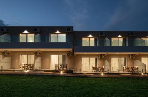 a building with tables and chairs in front of it at Diva Lodge in Sikia
