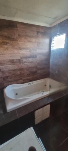 a bath tub in a bathroom with wooden walls at Casa con piscina mena in Los Andes
