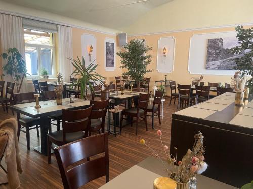 a restaurant with tables and chairs in a room at Harzhotel Warnstedter Krug in Thale