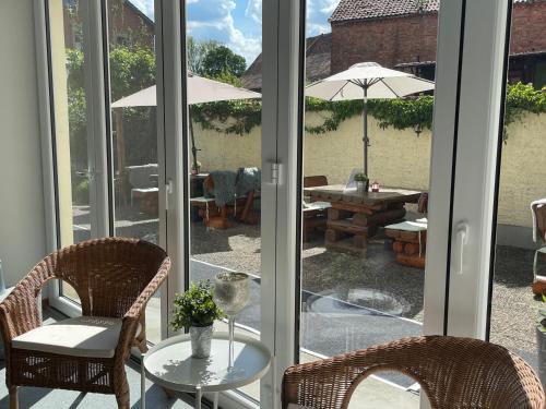 a patio with two chairs and a table with an umbrella at Harzhotel Warnstedter Krug in Thale