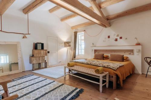 - une chambre avec un lit dans une pièce dotée de plafonds en bois dans l'établissement Maison 1643, à Laudun-l'Ardoise