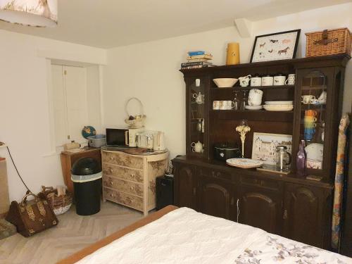 a room with a large wooden cabinet and a kitchen at Bright Cottage, kingdom of mourne in Ballynoe