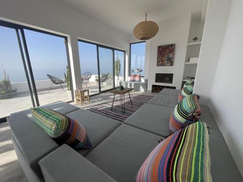 a living room with a couch and large windows at Dar Bouba, Cap Sim : la maison sur l'Océan in Wassane