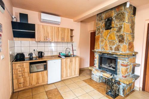 uma cozinha com uma lareira de pedra num quarto em Całoroczne Domki w Bieszczadach "The Willows" em Łączki