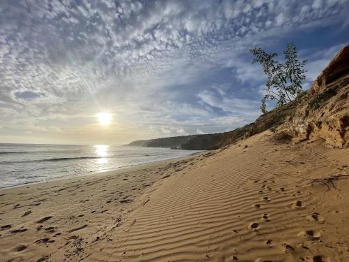 a beach with footprints in the sand and the ocean at Dar Bouba, Cap Sim : la maison sur l'Océan in Wassane