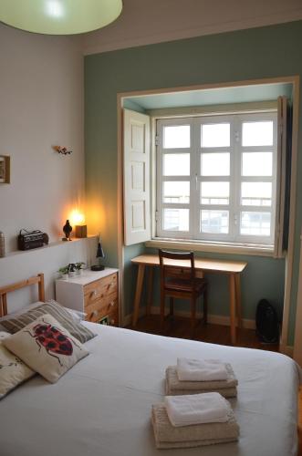 sypialnia z łóżkiem, biurkiem i oknem w obiekcie The Black Kitten II w mieście Caldas da Rainha