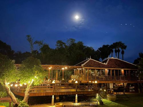 a house with a deck at night with the moon at Devi Kampot Resort at Phum Kampot in Kampot