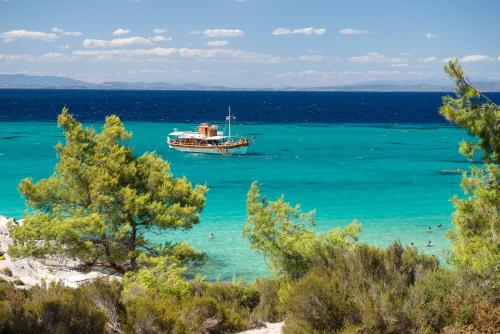 a boat in the ocean with people in the water at Diva Lodge in Sikia
