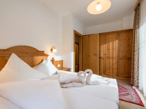 two swans sitting on a bed in a bedroom at S'Dörfl Chalets in Mayrhofen