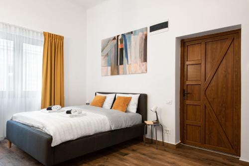 a bedroom with a bed and a wooden door at Studio in the heart of Cluj in Cluj-Napoca