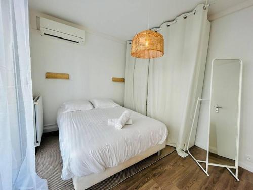 a bedroom with a white bed and a mirror at L'Héliodore, Apt 4 Prs Standing, Clim, Parking in Antibes