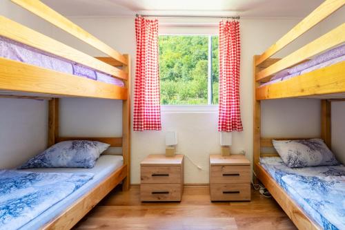two bunk beds in a room with a window at Domacinstvo na kraju svijeta in Šipovo