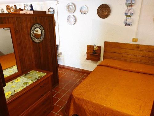 - une chambre avec un lit, une commode et des assiettes au mur dans l'établissement Basement Home, à Domusnovas
