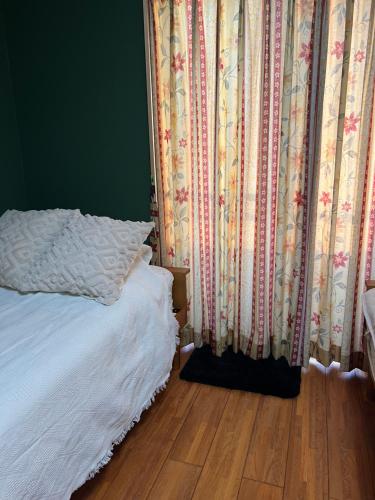 a bedroom with a bed and curtains and a wooden floor at Eishinan 栄進庵 in Fuji
