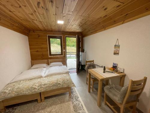 a bedroom with a bed and a desk and a table at Small house Floki in Žabljak
