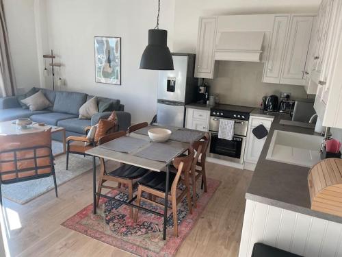 a kitchen and living room with a table and a couch at Stylish city-centre apartment with balcony in Liverpool