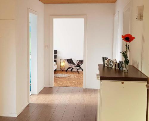 cocina con paredes blancas y pasillo con mesa en Haus am Bodensee, en Fußach