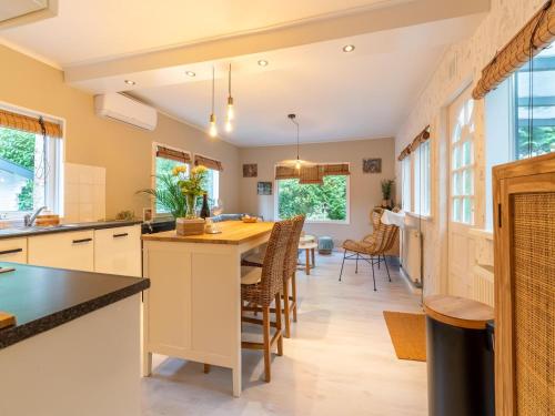 a kitchen with a table and chairs and windows at Holiday Home in Gelderland near Woodlands in Hattemerbroek