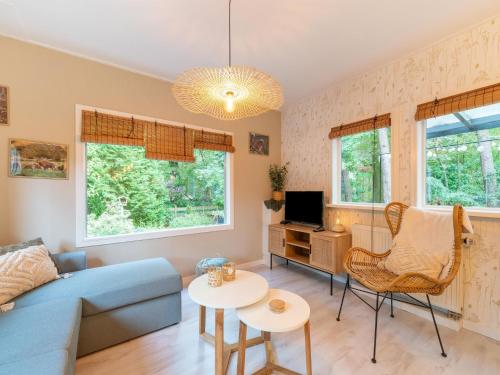 a living room with a blue couch and a table at Holiday Home in Gelderland near Woodlands in Hattemerbroek