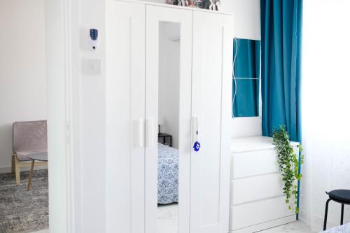a bedroom with a white closet with blue curtains at Lima Residence in Nicosia