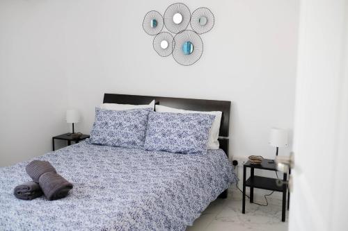 Schlafzimmer mit einem Bett mit blauer Decke und einem Spiegel in der Unterkunft Lima Residence in Nikosia