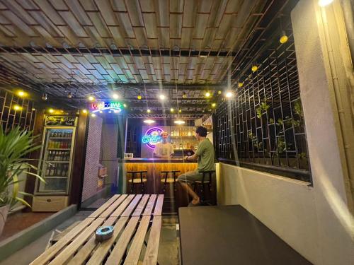 a man sitting at a bar in a pub at Mind Day Hostel Khaosan in Bangkok