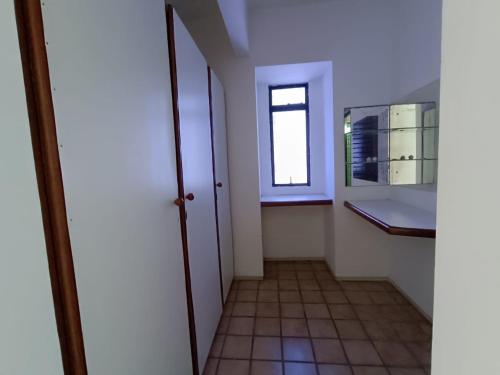 a hallway with a window and a tiled floor at HostellHouse Márcia Guimarães in João Pessoa